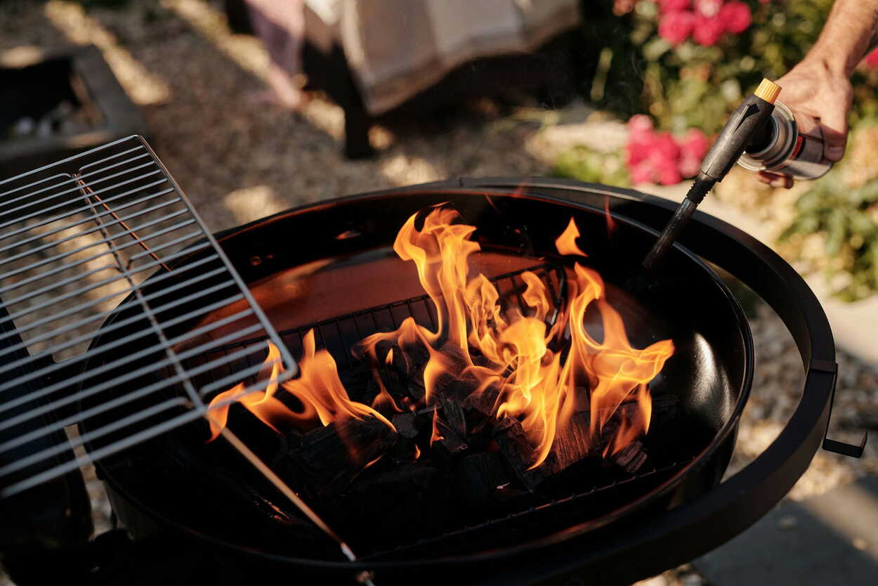Houtskool barbecue die wordt aangestoken